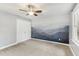 Bedroom features unique mountain wall art, ceiling fan, and neutral carpet at 1113 Harvest Mill Ct, Raleigh, NC 27610