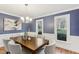 Well-lit dining room with a modern chandelier and picturesque windows overlooking the outdoor scenery at 1113 Harvest Mill Ct, Raleigh, NC 27610