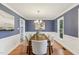 Formal dining room featuring wainscoting, a modern chandelier, and hardwood flooring at 1113 Harvest Mill Ct, Raleigh, NC 27610