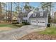 Charming two-story home with black shutters, gray siding, mature trees, and a well-manicured lawn at 1113 Harvest Mill Ct, Raleigh, NC 27610