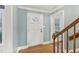 Light-filled foyer featuring hardwood floors, a white door with glass panes, and a staircase at 1113 Harvest Mill Ct, Raleigh, NC 27610