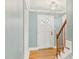 Light-filled foyer featuring hardwood floors, a white door with glass panes, and a staircase at 1113 Harvest Mill Ct, Raleigh, NC 27610
