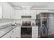 Bright kitchen featuring white cabinetry, granite countertops, and stainless steel appliances at 1113 Harvest Mill Ct, Raleigh, NC 27610