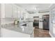Well-lit kitchen with white cabinetry, granite countertops, and stainless steel refrigerator at 1113 Harvest Mill Ct, Raleigh, NC 27610