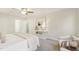 Sun-filled main bedroom featuring a ceiling fan, beige carpet, a console table, and two accent chairs at 1113 Harvest Mill Ct, Raleigh, NC 27610