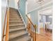 Traditional staircase with carpeted steps and wood railing leads to the upper level of the home at 1113 Harvest Mill Ct, Raleigh, NC 27610