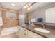 This bathroom has tile flooring, double sinks, and a shower and bath with a light brown tile surround at 116 Galway Dr, Chapel Hill, NC 27517