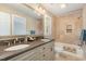 This bathroom features tile flooring, double sinks, and a shower and bath with a light brown tile surround at 116 Galway Dr, Chapel Hill, NC 27517