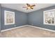 This spacious bedroom features carpet flooring, blue walls, and two windows for plenty of natural light at 116 Galway Dr, Chapel Hill, NC 27517