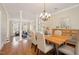 Bright dining room adjacent to living area, featuring hardwood floors, white columns, and a chandelier at 116 Galway Dr, Chapel Hill, NC 27517