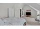 Upstairs bedroom featuring sloped walls, a tv, and a bed with white and gray bedding at 117 Talley Ridge Dr, Holly Springs, NC 27540