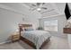 This bedroom features a tray ceiling, ceiling fan, large window and a wooden bed frame at 117 Talley Ridge Dr, Holly Springs, NC 27540