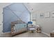Bedroom with geometric accent wall, wooden crib, and lots of natural light at 117 Talley Ridge Dr, Holly Springs, NC 27540