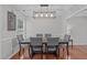 Dining room with a large table, seating for six, a statement light fixture and a view to the kitchen at 117 Talley Ridge Dr, Holly Springs, NC 27540