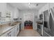 Well-lit kitchen with stainless steel appliances, granite countertops and a view to the dining room at 117 Talley Ridge Dr, Holly Springs, NC 27540
