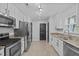 Bright kitchen with stainless steel appliances, light countertops, and a view to the adjacent dining room at 117 Talley Ridge Dr, Holly Springs, NC 27540