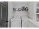 Functional laundry area with washer, dryer, and shelving for storage and organization at 117 Talley Ridge Dr, Holly Springs, NC 27540