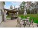 Back patio with a gazebo, outdoor seating, dining table, and a lush green yard at 117 Talley Ridge Dr, Holly Springs, NC 27540