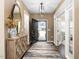 Inviting entryway featuring hardwood floors, stylish rug, decorative mirror, and ample natural light at 1214 Gaston Manor Dr, Durham, NC 27703