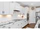 Well-equipped kitchen showcasing white cabinets, granite countertops, tile backsplash, and stainless steel appliances at 1214 Gaston Manor Dr, Durham, NC 27703