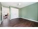 Bedroom with green walls, ceiling fan, wood-look flooring, closet, and doorway to adjacent room at 1234 Berkeley St, Durham, NC 27705