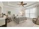 Comfortable bedroom featuring a tray ceiling, ceiling fan, and a cozy rocking chair at 1407 Palmer Hill Dr, Durham, NC 27703