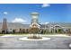 Community clubhouse with a clock tower, manicured landscaping, and circle driveway at 1407 Palmer Hill Dr, Durham, NC 27703