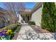 Landscaped walkway leading to a covered porch, framed by lush plantings and colorful flowers at 1407 Palmer Hill Dr, Durham, NC 27703