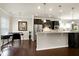 Well-lit kitchen with dark cabinetry, stainless steel appliances, and adjacent dining area at 1407 Palmer Hill Dr, Durham, NC 27703