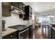 Modern kitchen with stainless steel appliances, dark cabinetry, and an open layout to the living room at 1407 Palmer Hill Dr, Durham, NC 27703