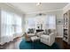 Bright sitting area features large windows, two chairs, and an ottoman on a blue rug at 1407 Palmer Hill Dr, Durham, NC 27703