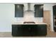 Modern kitchen featuring sleek cabinets, stainless steel range hood, and a white backsplash at 1511 Malcus Ct # 64, Fuquay Varina, NC 27526
