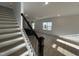 Bright, open-concept living room featuring light wood floors, a modern staircase, and natural light at 1511 Malcus Ct # 64, Fuquay Varina, NC 27526