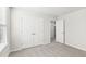 This bedroom features neutral carpeting, a window with white blinds, and a closet at 153 Klamath Dr, Garner, NC 27529