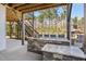 Stylish outdoor kitchen with a stone countertop, bar stools, and a covered patio area at 1532 Champlain Crest Way, Cary, NC 27513