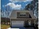 Charming home featuring a gray exterior, garage, manicured lawn, and well-maintained landscaping at 169 Black Cloud Dr, Louisburg, NC 27549
