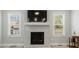 Living room with tiled fireplace, mounted tv, and windows with outside view at 169 Black Cloud Dr, Louisburg, NC 27549