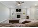Inviting living room features a fireplace, mounted TV, ceiling fan, and wood floors at 169 Black Cloud Dr, Louisburg, NC 27549