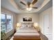 Staged bedroom featuring a tray ceiling, large window, and neutral tones at 2013 Turtle Point Dr, Raleigh, NC 27604