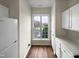 Bright kitchen with white cabinets and appliances, hardwood floors, and a view to the exterior at 2013 Turtle Point Dr, Raleigh, NC 27604