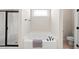 Bathroom showcasing a white tiled bathtub, shower, and a window above the tub at 21 Tracker Ct, Garner, NC 27529