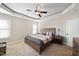 Comfortable bedroom featuring a ceiling fan, tray ceiling and neutral walls at 21 Tracker Ct, Garner, NC 27529