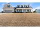 Inviting two-story home featuring dormer windows, covered porch, attached garage, and lawn on a sunny day at 21 Tracker Ct, Garner, NC 27529