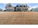 Inviting two-story home featuring dormer windows, covered porch, attached garage, and lawn on a sunny day at 21 Tracker Ct, Garner, NC 27529