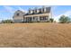 Inviting two-story home featuring dormer windows, covered porch, attached garage, and lawn on a sunny day at 21 Tracker Ct, Garner, NC 27529