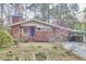 Quaint single-story brick home with a carport, chimney, and blossoming tree in the front yard at 2208 Tampa Ave, Durham, NC 27705