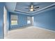 Bright bedroom with tray ceiling, windows, and neutral carpet at 241 Westgrove Ct, Durham, NC 27703