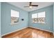 Light blue bedroom with hardwood floors, white blinds, and natural light at 241 Westgrove Ct, Durham, NC 27703