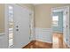 Bright foyer with white front door, wood floors, and elegant wainscoting at 241 Westgrove Ct, Durham, NC 27703