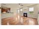 Open-concept living room featuring hardwood floors, fireplace, and kitchen view at 241 Westgrove Ct, Durham, NC 27703